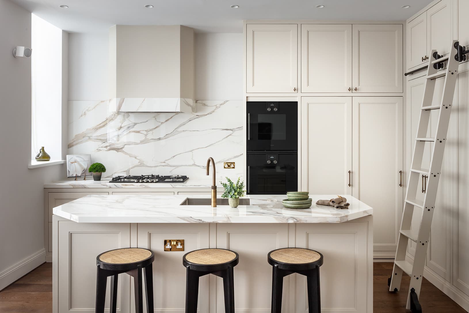 Classic white island kitchen with bar stools and marble worktop