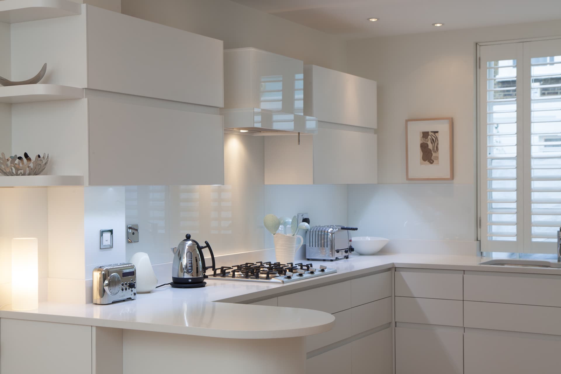 Sleek white contemporary kitchen with curved peninsula
