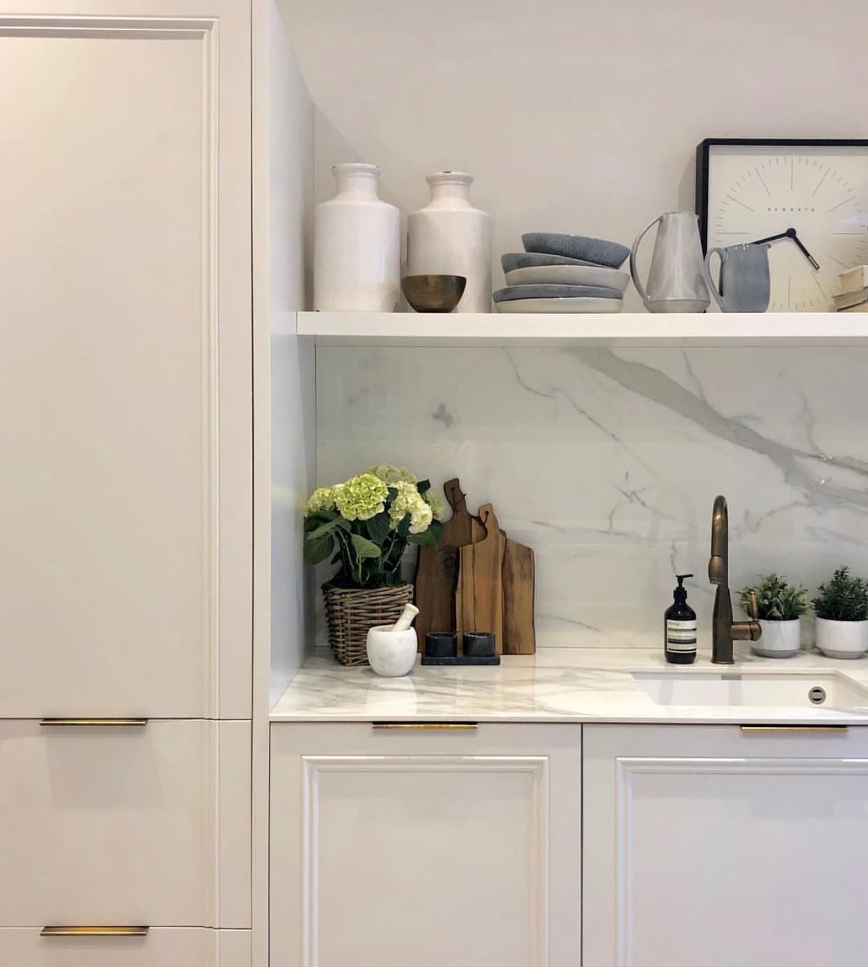 Open shelving with marble backsplash and styled ceramics