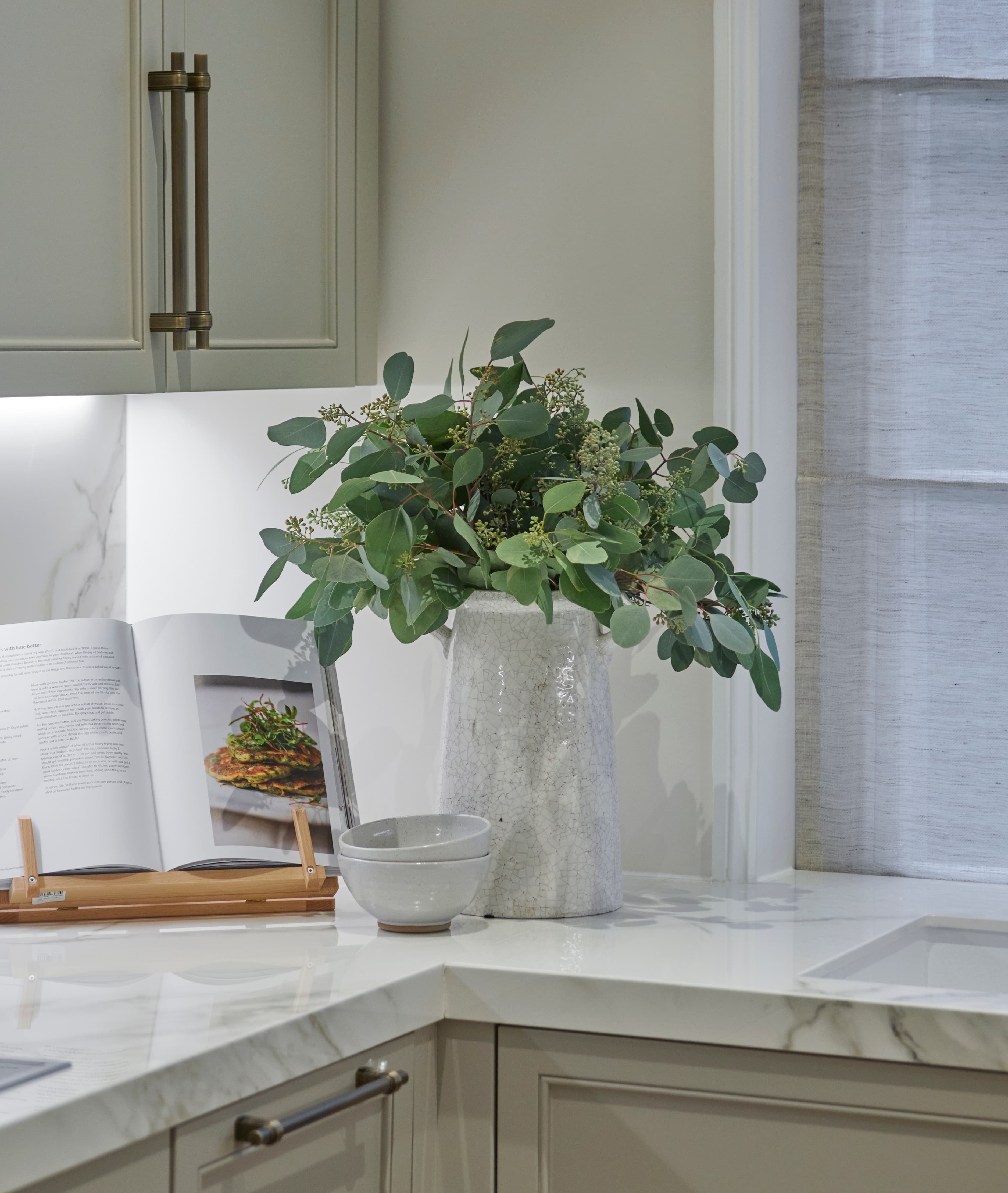 Sage corner detail with eucalyptus arrangement and marble