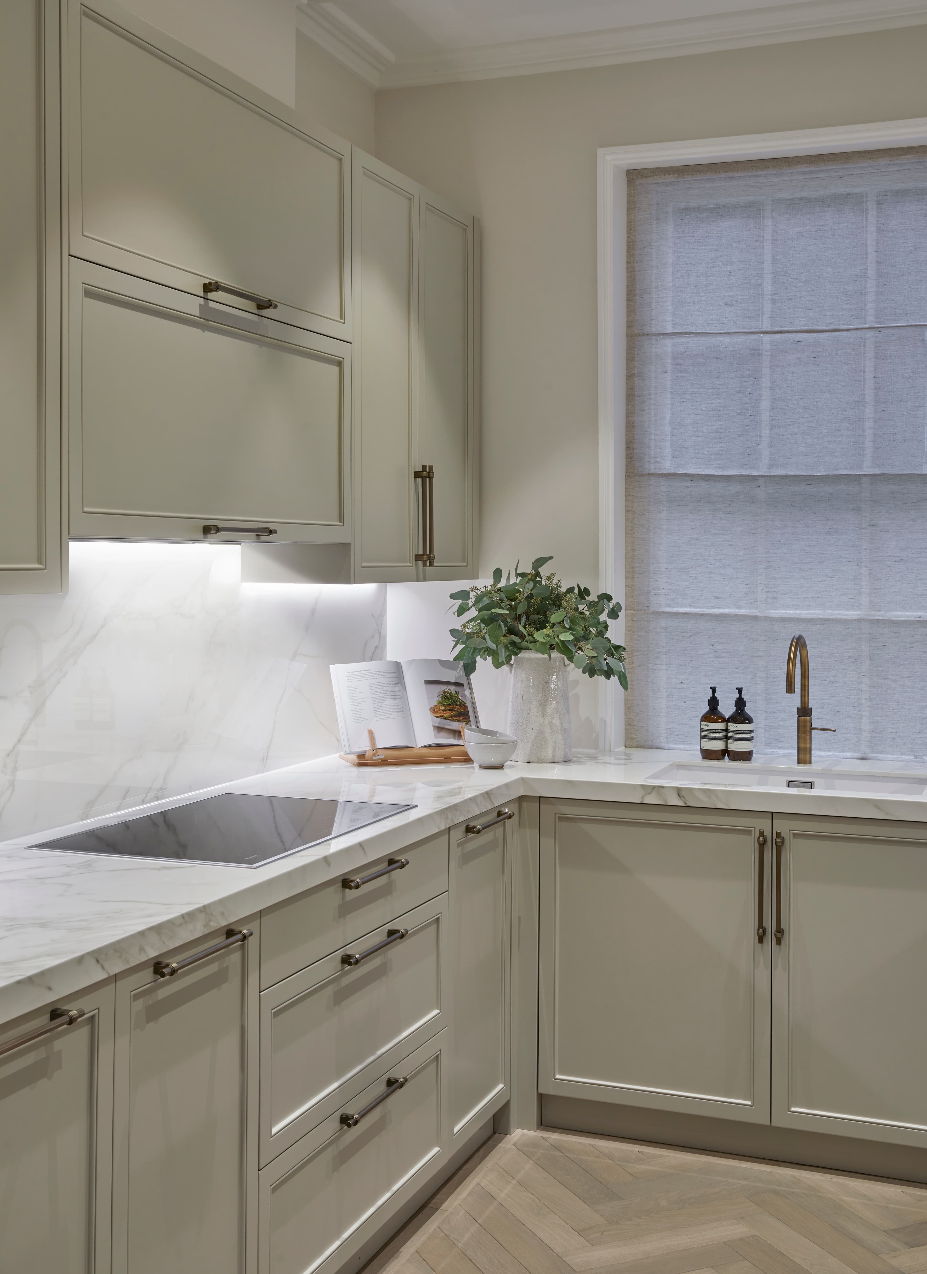 Sage green kitchen with herringbone parquet flooring