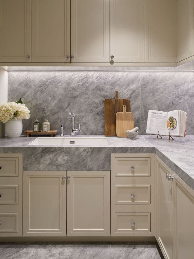 Hand-painted sage green cabinets with grey marble backsplash