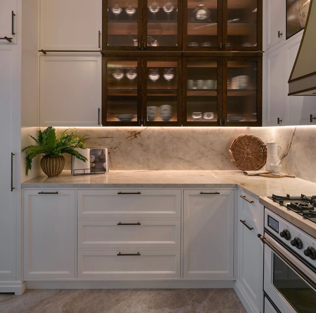 White in-frame kitchen with glass display cabinets and range